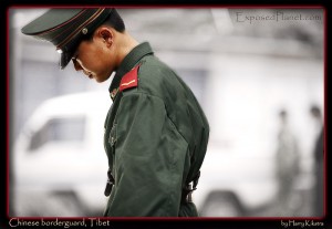 Chinese borderguard thinking, friendship bridge, border Tibet-Nepal. (c) Harry Kikstra, ExposedPlanet.com